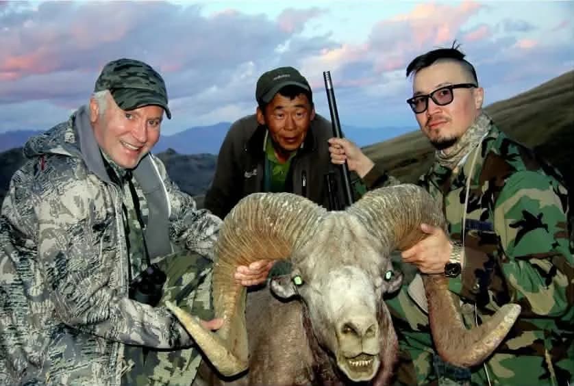 Hunters with an argali ram in the mountains of Mongolia